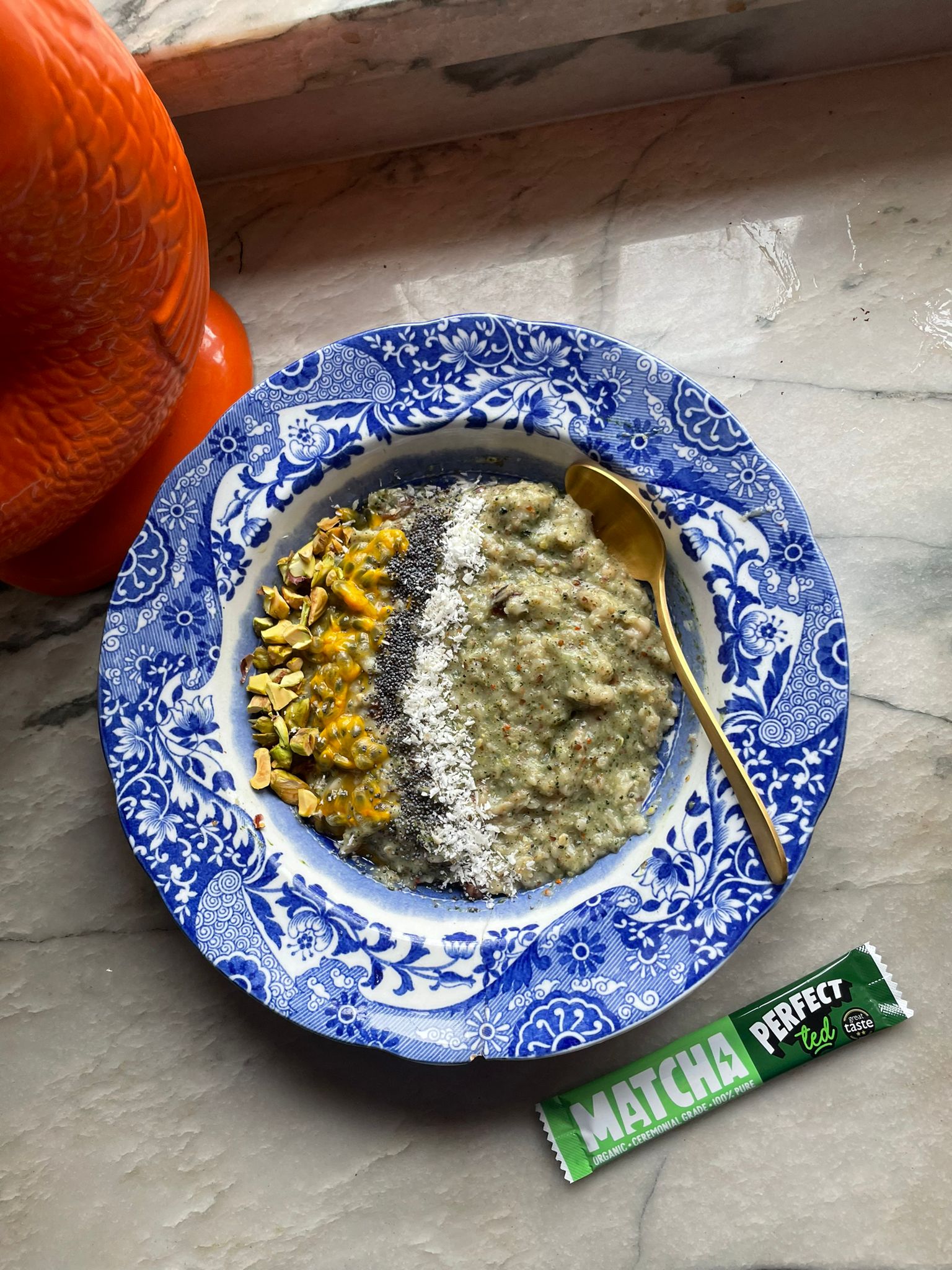 Bowl of Matcha Porridge with passionfruit and chia seeds on grey marble surface