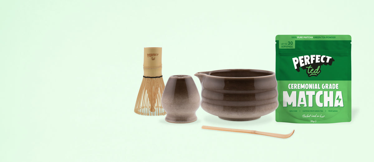 a bowl and a cup with a bamboo whisk