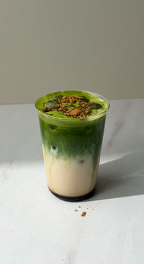 a green and white drink in a plastic cup