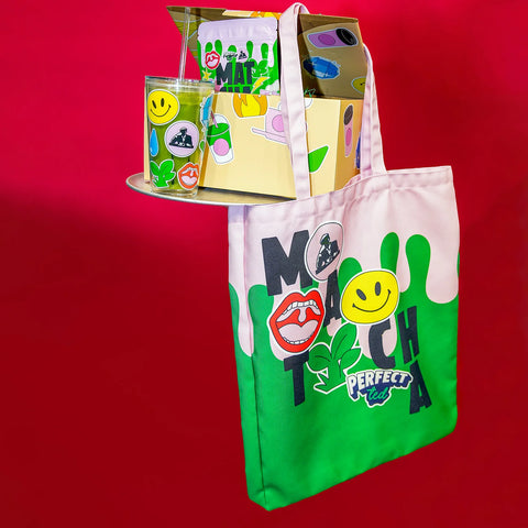 Bundle box with matcha powder and cup in the box with tote bag hanging off the side