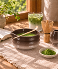 a bowl of green tea with a spoon and a glass of green tea