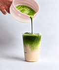 a person pouring green liquid into a glass